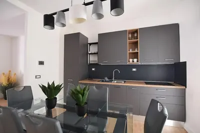 a kitchen with a glass table and a sink at iFlat Normanni Lounge Apartment in Palermo