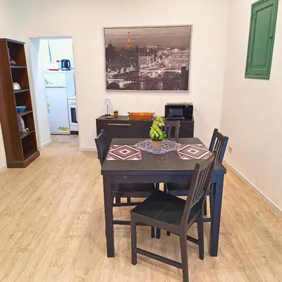 a dining room with a table and chairs and a kitchen at [CENTRO STORICO] Casa Bellini ***** in Palermo