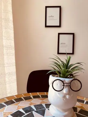 a vase with glasses sitting on a table with a plant at Monteleone rooms in Palermo