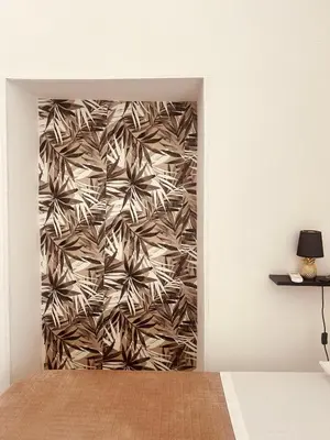 a hallway with a wall with a mural of palm trees at Monteleone rooms in Palermo