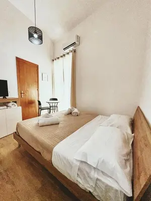a bedroom with a bed with a table and a window at Monteleone rooms in Palermo