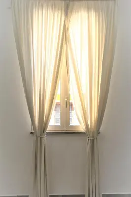 a window with white curtains in a room at Casa Vacanze Deianira in Santa Flavia