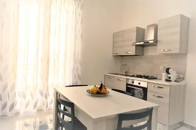 a kitchen with a table with a bowl of fruit on it at Casa Vacanze Deianira in Santa Flavia