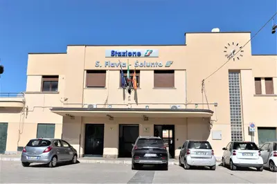 a building with cars parked in a parking lot at Casa Vacanze Altea in Santa Flavia