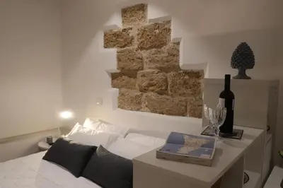 a bedroom with a bed and a table with a bottle of wine at Casuzza palazzo storico, Stazione Centrale Palermo in Palermo