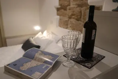 a bottle of wine and a glass on a table at Casuzza palazzo storico, Stazione Centrale Palermo in Palermo