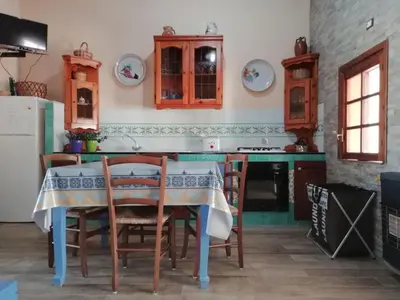 a kitchen with a table and some chairs and a stove at Vista sul mare e splendido terrazzo in Castellammare del Golfo