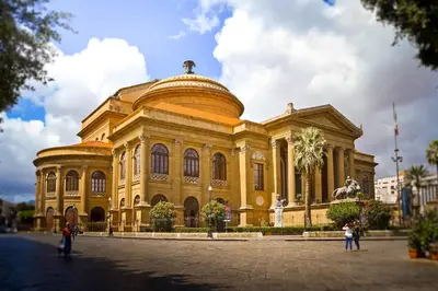 a large yellow building with people standing in front of it at Capo Seralcadio in Palermo