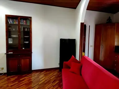 a living room with a red couch and a book shelf at Capo Seralcadio in Palermo