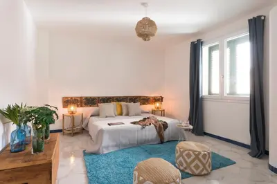 a bedroom with a bed and a blue rug at Sant'Elia Luxury Home&Spa con accesso al mare in Santa Flavia