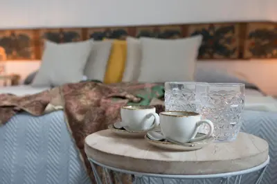 a table with two cups and a glass on a bed at Sant'Elia Luxury Home&Spa con accesso al mare in Santa Flavia