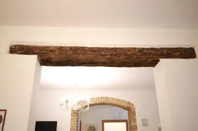 a beam on the ceiling of a room with a fireplace at La Maison Du Centre in Palermo