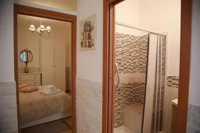 a bathroom with a glass door leading to a bedroom at La Maison Du Centre in Palermo