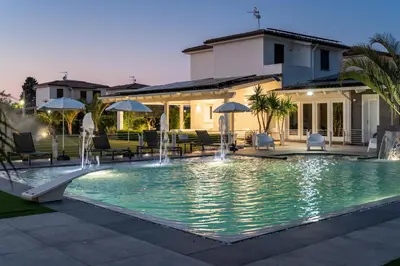 a swimming pool with chairs and umbrellas in a resort at Villa Solià - Villa indipendente con Piscina e Giardino in Campofelice di Roccella