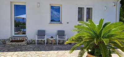 two chairs and a table in front of a house at Villa Ballerina Bianca in Scopello