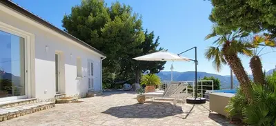 a patio with a chair and an umbrella at Villa Ballerina Bianca in Scopello