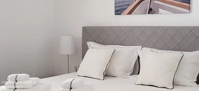 a bedroom with a bed with white pillows at Villa Ballerina Bianca in Scopello