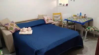 a bedroom with a blue bed and a table with chairs at Sikulamente in Palermo