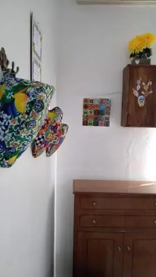 a bedroom with a wooden dresser and a pillow and pictures at Sikulamente in Palermo