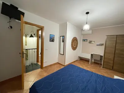 two beds in a room with blue sheets at Rosa Di Makari in Macari