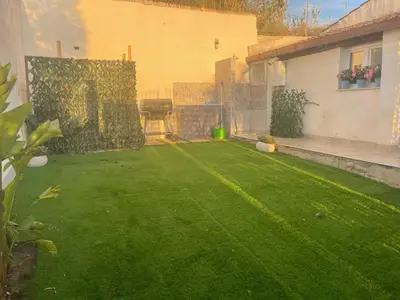 a backyard with a green lawn and a house at Villa Vittoria in Trappeto