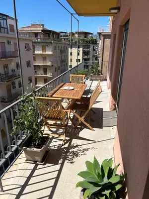 a wooden table and chairs on a balcony at SiSo Home in Palermo