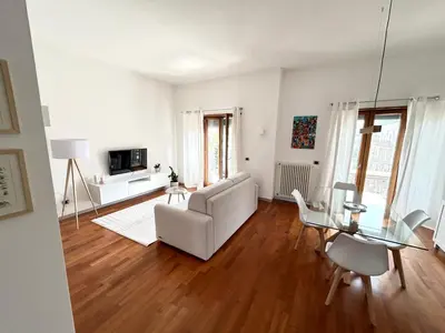a living room with a white couch and a glass table at SiSo Home in Palermo