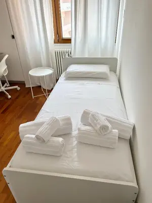 a bedroom with two beds with white sheets and towels at SiSo Home in Palermo