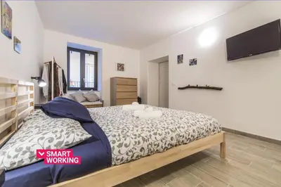 a bedroom with a large bed with a tv on the wall at Vuccirihouse in Palermo