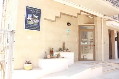 a crowd of people sitting on steps in front of a building at Affittacamere Indios in Cerda