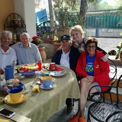 a group of people sitting at a table with food at The Garden in Sferracavallo