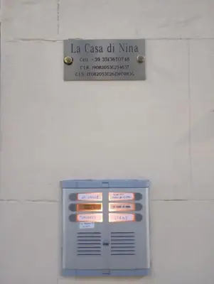 a sign on the wall of a building at La Casa di Nina in Palermo