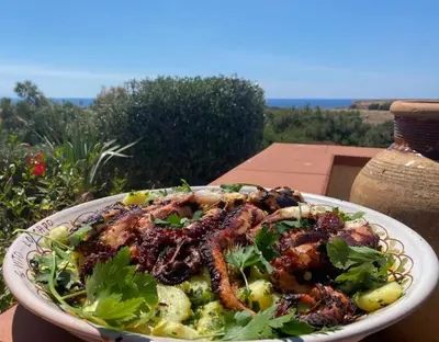 a plate of food with meat and vegetables on a table at VILLA FLAMINIA - con piscina privata in San Vito lo Capo
