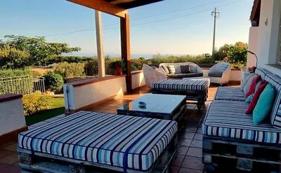 a patio with two couches and a table and chairs at VILLA FLAMINIA - con piscina privata in San Vito lo Capo
