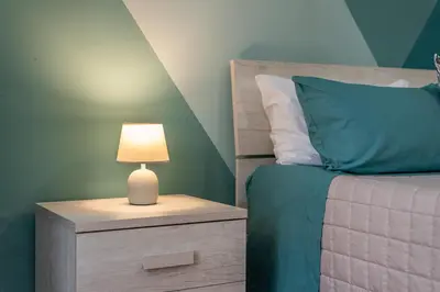 a bedroom with a bed with a lamp on a night stand at Good Vibes apartment nel centro storico in Palermo