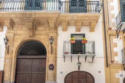 a building with two doors and a balcony with flowers on it at Good Vibes apartment nel centro storico in Palermo