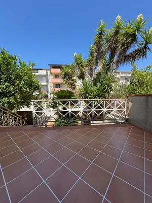 a tile patio with a white fence and palm trees at CASA CRETTO in Salaparuta