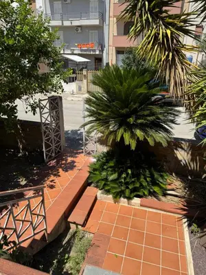 a brick walkway with a palm tree and a building at CASA CRETTO in Salaparuta