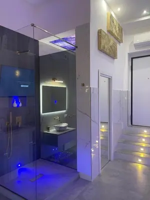 a bathroom with a glass shower and a sink at ARCUM suites in Palermo