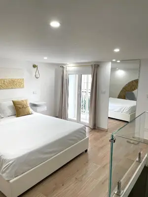 a white bedroom with a large bed and a window at ARCUM suites in Palermo