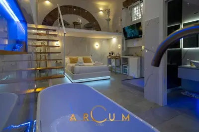 a living room with a bed and a kitchen at ARCUM suites in Palermo