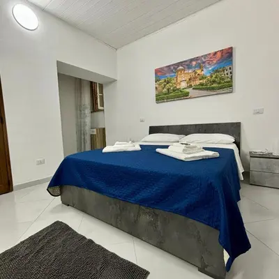 a bedroom with a bed with a blue blanket at Casa vacanze La Bonta' di Palermo in Palermo