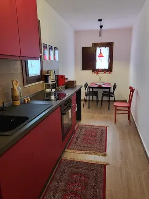 a kitchen with red cabinets and a dining table at Patrizia Chic in Palermo