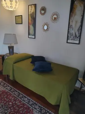 a bedroom with a green bed with pillows on it at Patrizia Chic in Palermo