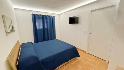 a bedroom with a blue bed and a window at Casa del Limone in Isola delle Femmine