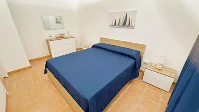 a bedroom with a blue bed in a room at Casa del Limone in Isola delle Femmine