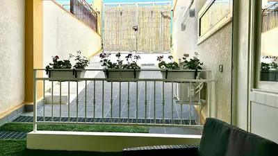 a balcony with three potted plants on a railing at Casa del Limone in Isola delle Femmine