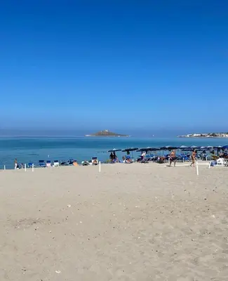 a beach with people on the sand and the ocean at Casa del Limone in Isola delle Femmine