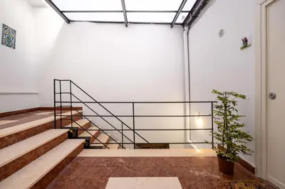 a staircase in a building with a potted plant at Agata & Rosalia 2 Suite Indipendenti e Comunicanti con Balcone & AC in Palermo