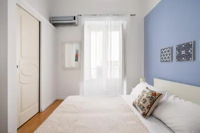 a white bedroom with a bed and a window at Agata & Rosalia 2 Suite Indipendenti e Comunicanti con Balcone & AC in Palermo